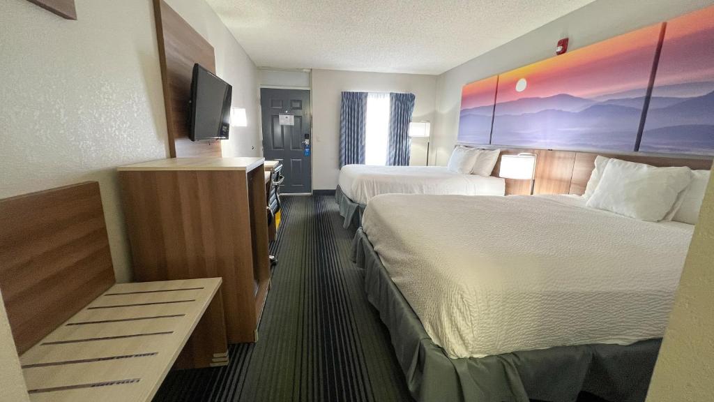 a hotel room with two beds and a flat screen tv at Days Inn by Wyndham Harrison in Harrison