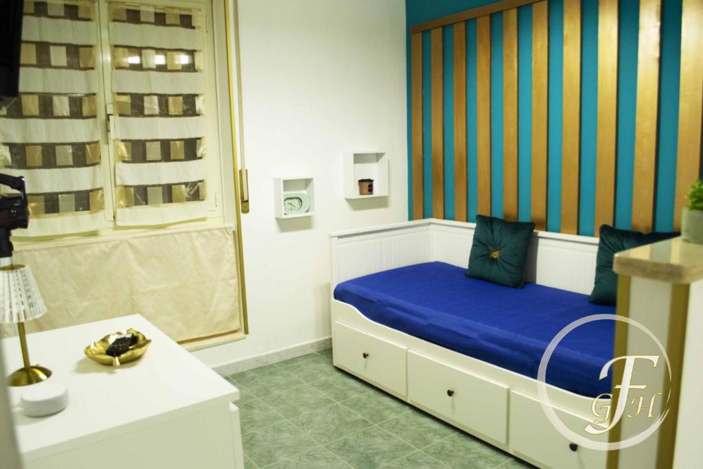 1 dormitorio con cama con sábanas azules y ventana en Fenty Guest House en Roma