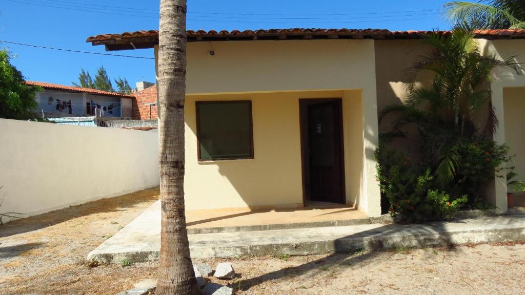 uma pequena casa com uma palmeira em frente em Morada dos Ventos em Fortaleza