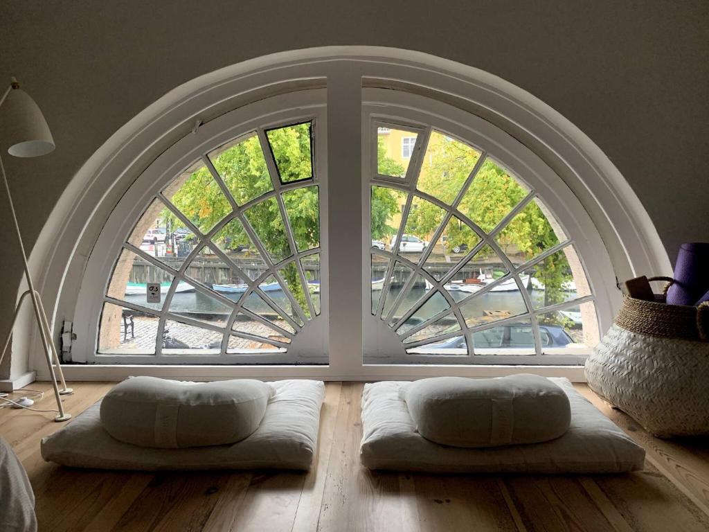 a room with a large window with two pillows on the floor at Christianshavn Canalside Luxury Apartment in Copenhagen