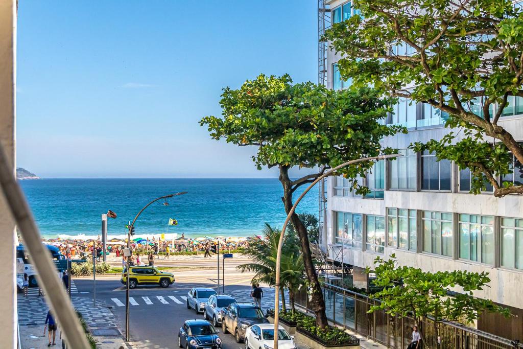 vistas a una playa con un edificio y al océano en Vinicius de Moraes Ipanema Apartment, en Río de Janeiro