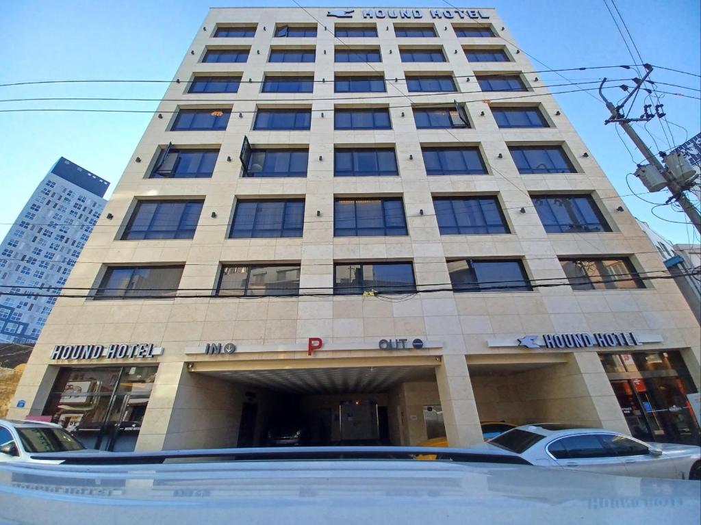 a tall building with cars parked in front of it at Gwangju HOUND Hotel in Gwangju