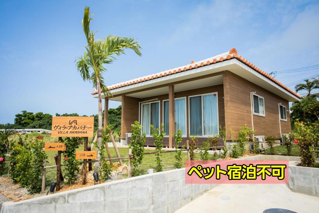 una casa con un cartel delante de ella en ヴィラ・アカバナー　A棟, en Isla Miyako
