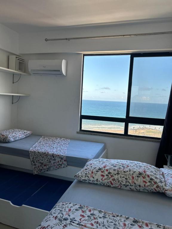 um quarto com 2 camas e vista para o oceano em Maravilhosa cobertura duplex vista mar em Salvador