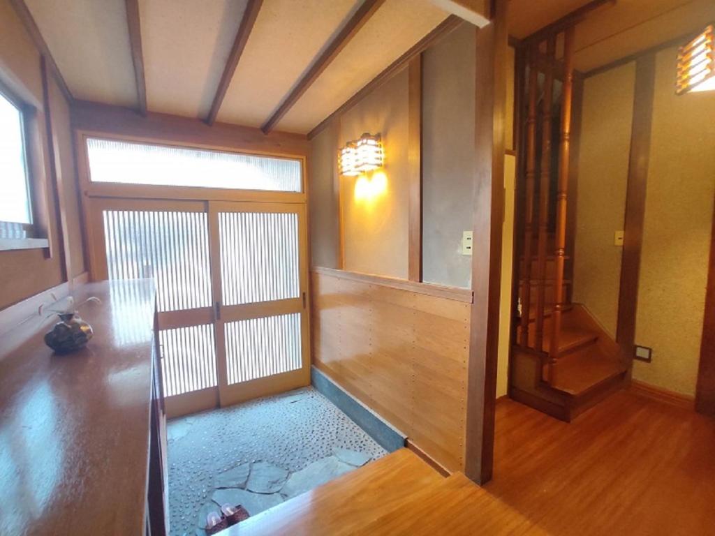 una habitación vacía con una puerta y un pasillo en Guesthouse Kincha 駅東口, en Utsunomiya