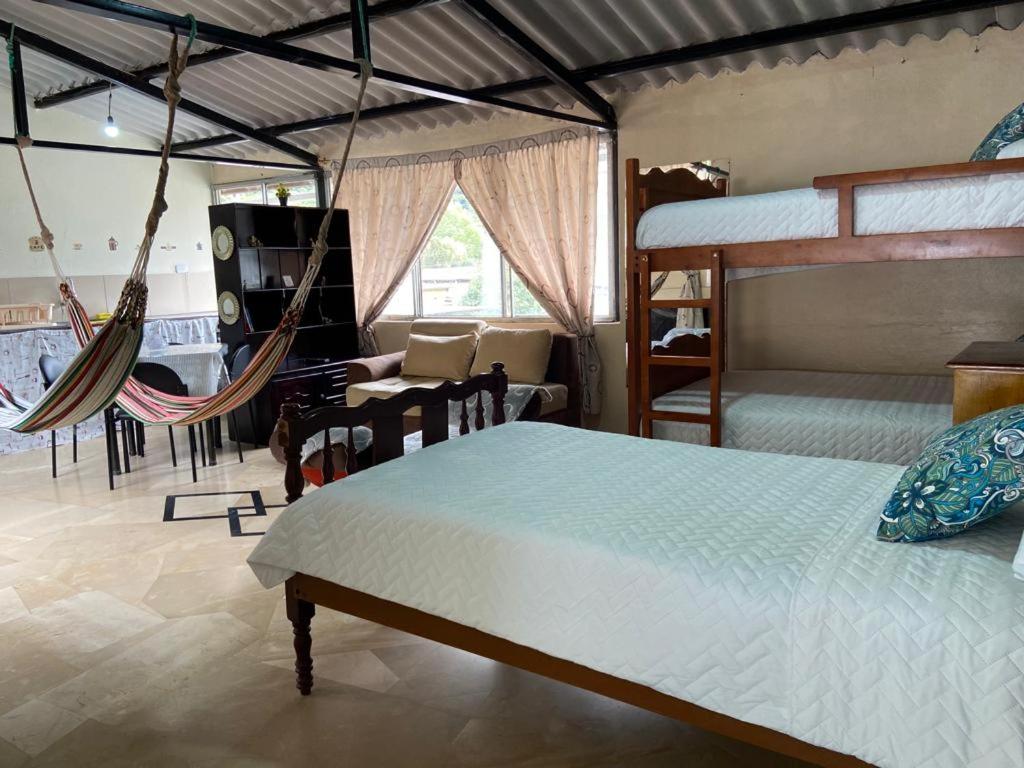 a bedroom with two beds and a hammock at APARTAMENTO ESTUDIO - COMPLETO Y MUY BIEN UBICADO in Baños