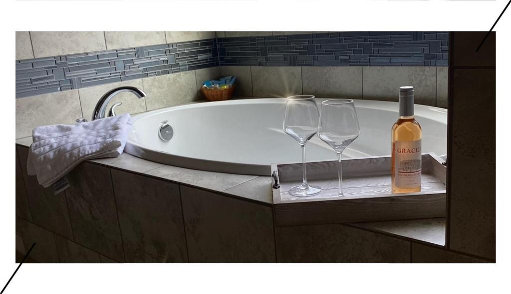a bath tub with two glasses and a bottle of wine at Relaxing Retreat Early check in & late check out in Houston