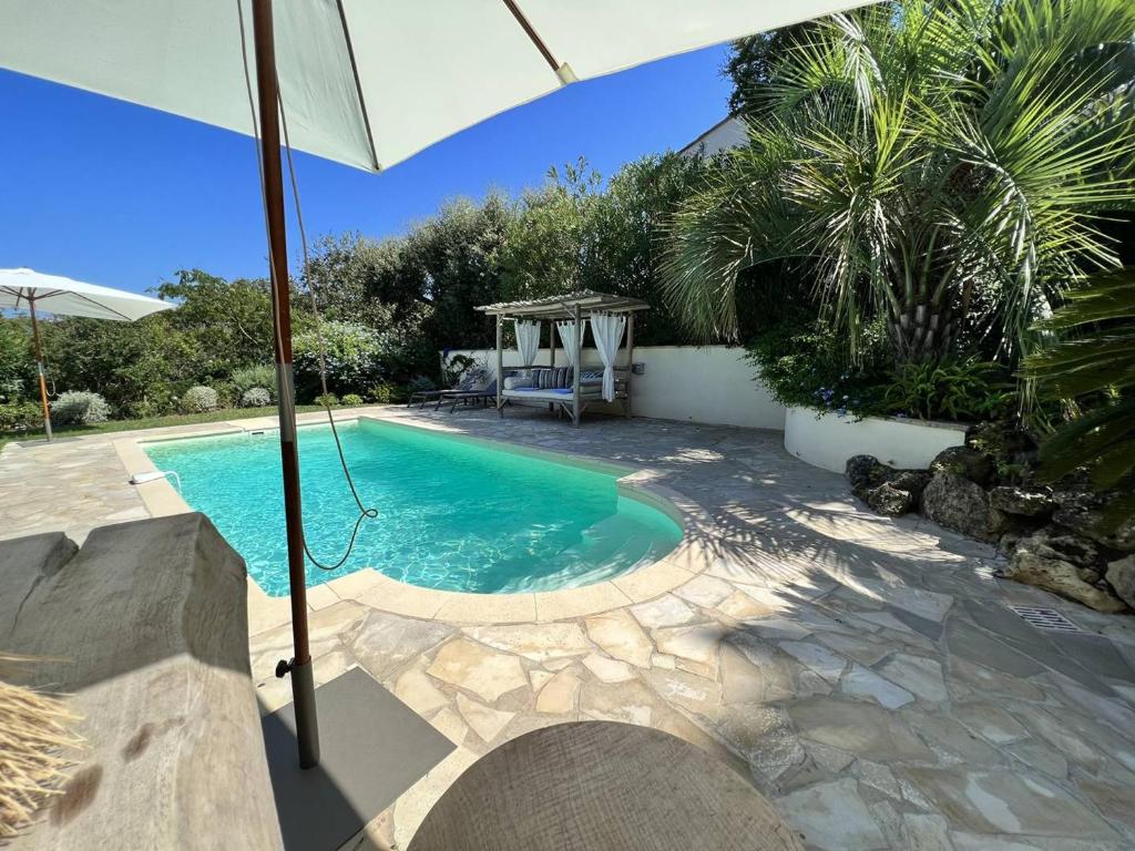 einen Pool mit Sonnenschirm im Hof in der Unterkunft Villa La Croix-Valmer, 5 pièces, 8 personnes - FR-1-726-32 in La Croix-Valmer