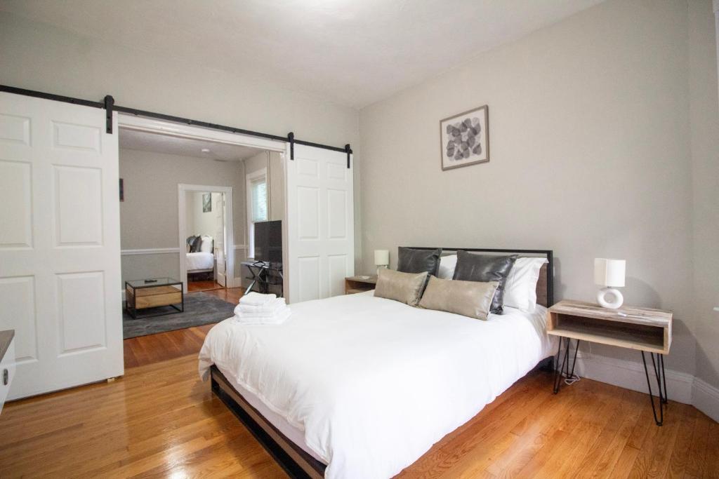 a bedroom with a large white bed and a mirror at 2 bedroom condo close to Boston and Cambridge with free parkings in Boston