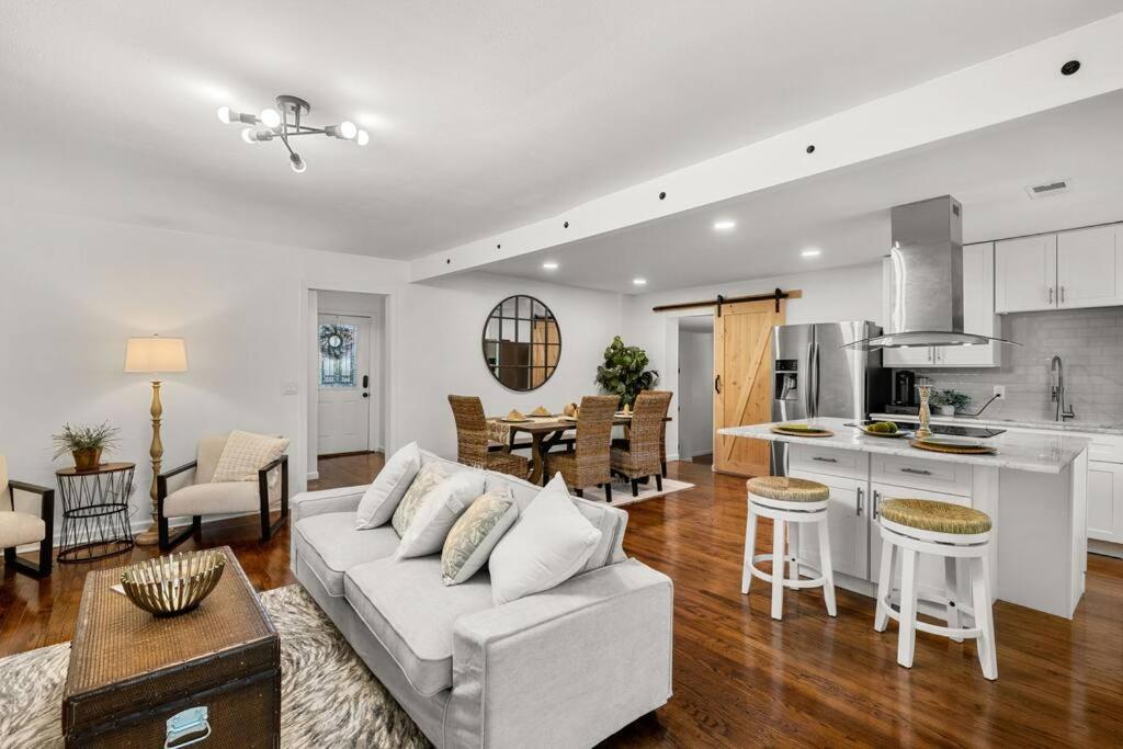 uma sala de estar com um sofá branco e uma cozinha em The Oak House em Charleston
