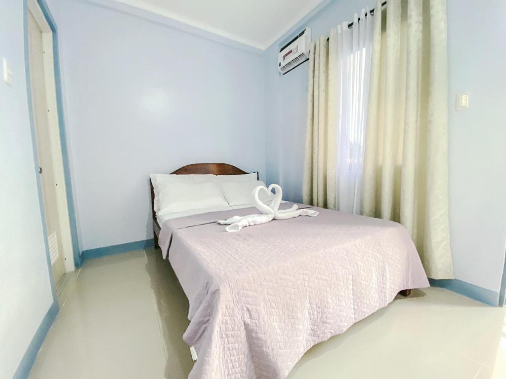 a bedroom with a bed with a ribbon on it at Althea Apartelle in Moalboal