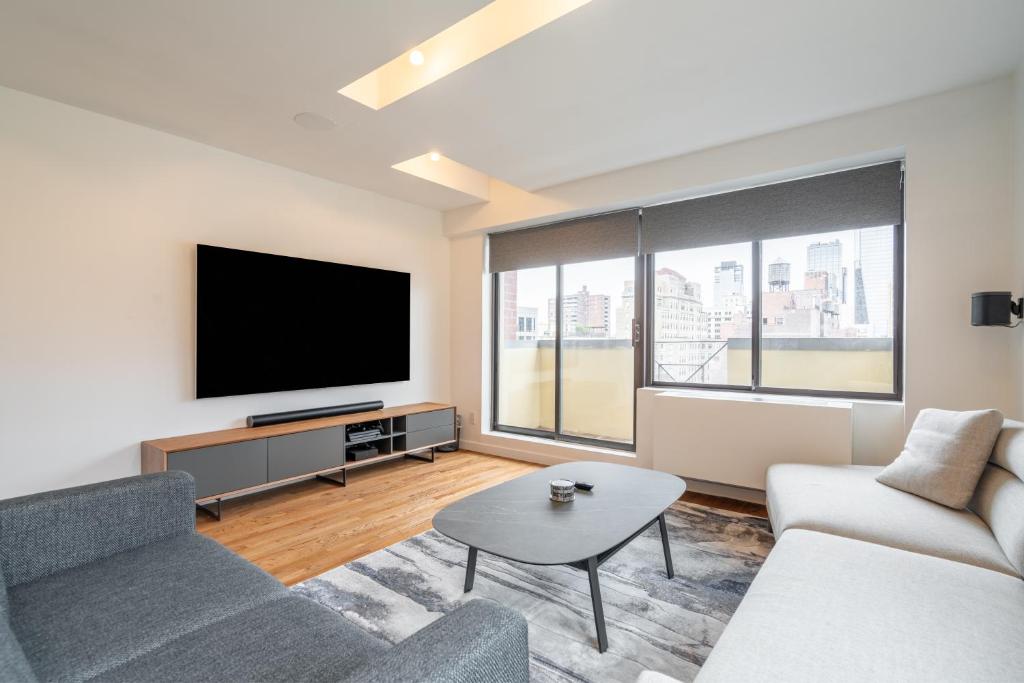 ein Wohnzimmer mit einem Sofa und einem TV in der Unterkunft Eden, dream high-end home in NYC in New York