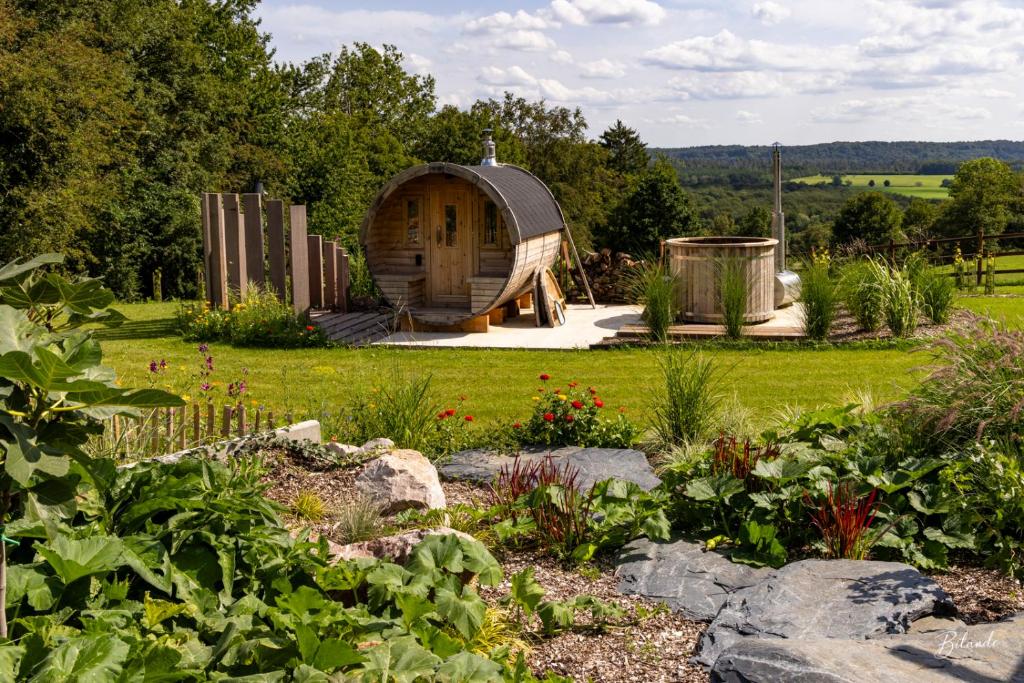 un jardin avec une cabane en bois dans un champ dans l'établissement la chocolaterie, à Roly