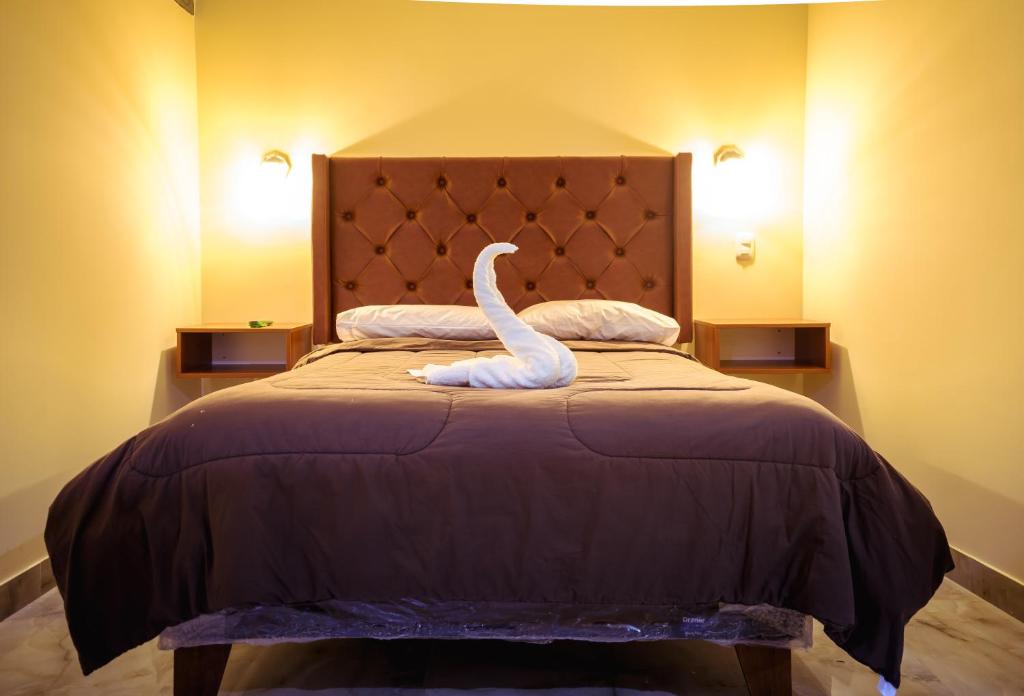 a white swan statue sitting on top of a bed at CASA ESTEVES in Ollantaytambo