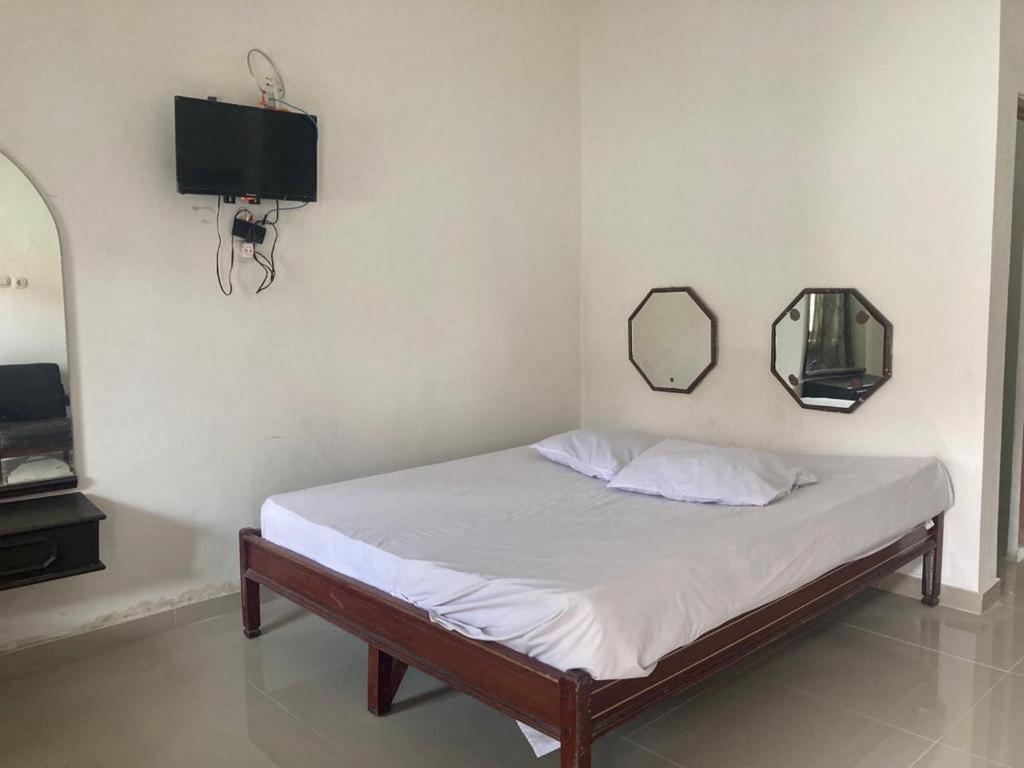 1 dormitorio con 1 cama con espejo y TV en Hotel Surya Citra Jogja A Mitra RedDoorz, en Timuran