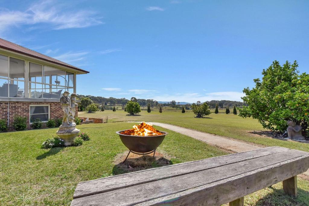 a fire pit sitting next to a wooden bench at Noble Willow Estate in Lovedale