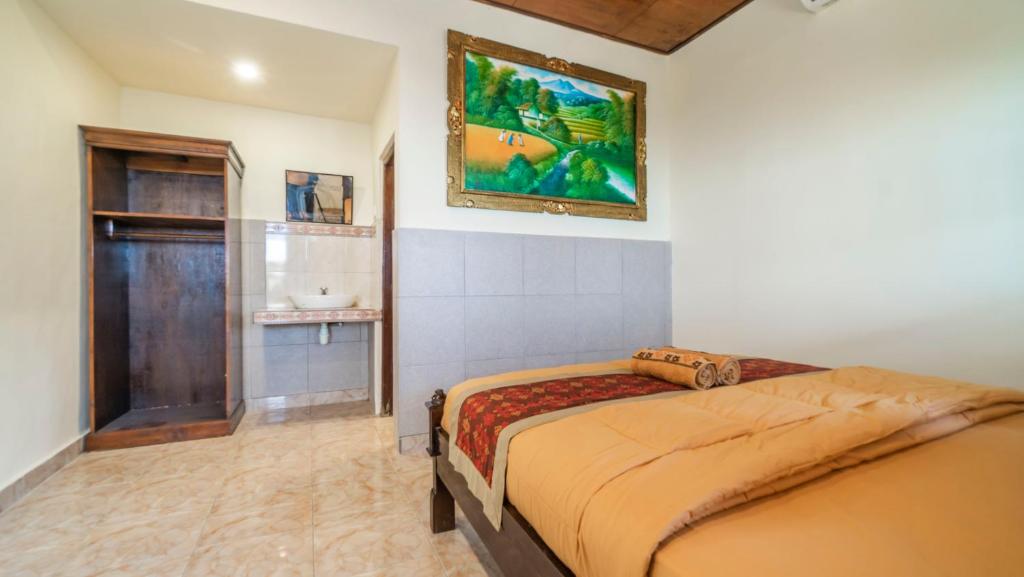 um quarto com uma cama e um quadro na parede em Amel House Ubud em Ubud