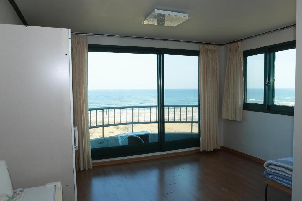 una camera con una grande finestra con vista sull'oceano di Mangsang Beach Pension a Gangneung