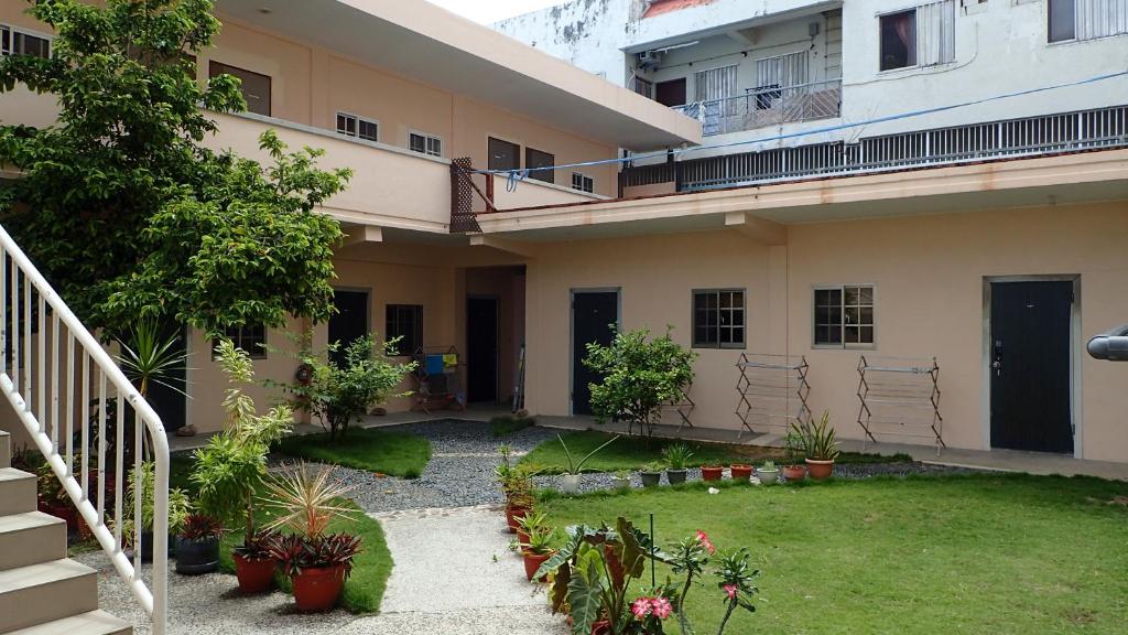 a courtyard of a building with a yard with plants at Oh My House in Garapan