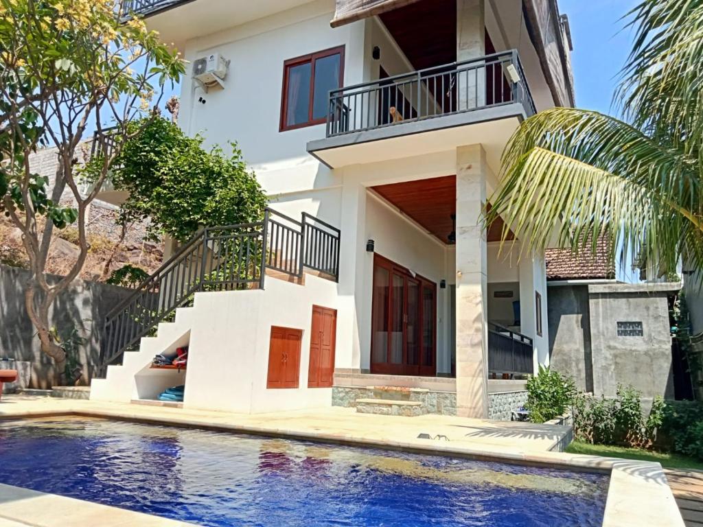 a house with a swimming pool in front of a house at Pondok Wisata Balty Bali in Amed