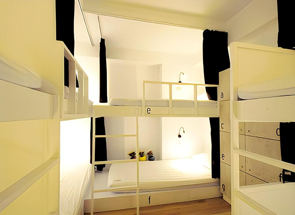 a room with white bunk beds and a window at We Come Hostel in Taipei