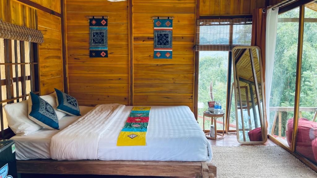 una camera con un letto su una parete in legno di Du Gia Panorama a Làng Cac