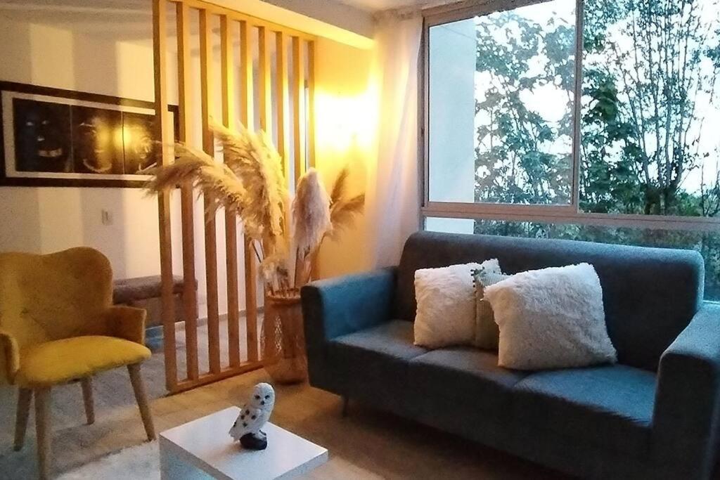 sala de estar con sofá azul y silla en Apartamento Manizales Colombia en Manizales