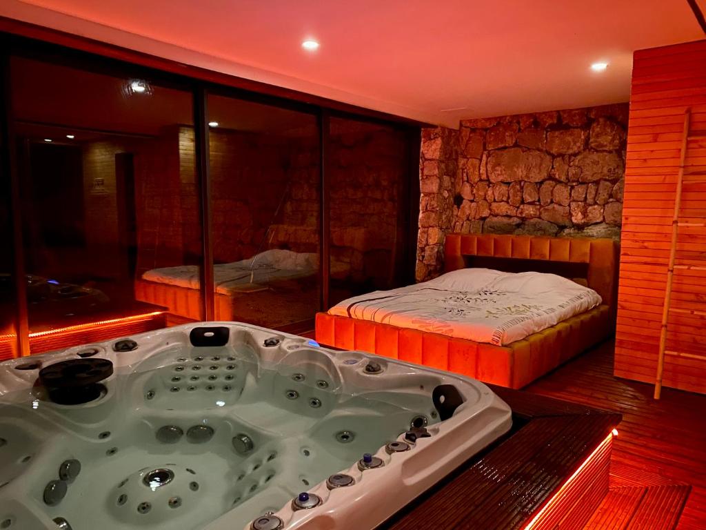 un bagno con vasca e un letto di Villa & Spa Mas des Oliviers a Châteauneuf