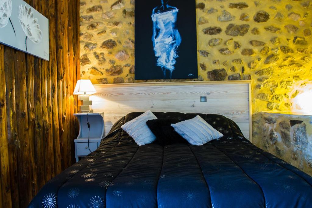1 dormitorio con 1 cama y una pintura en la pared en L'Armourier, en Largentière