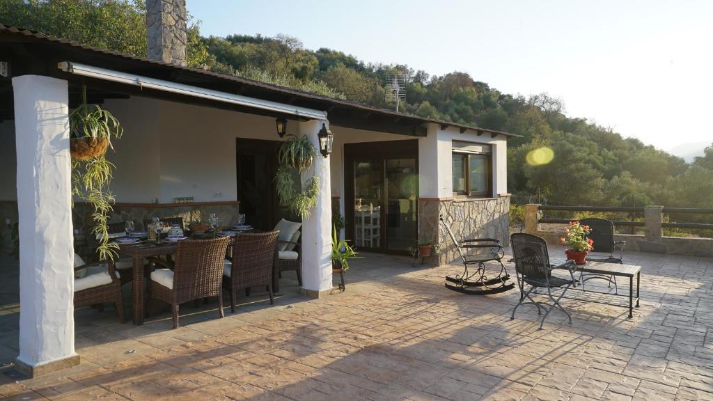 a house with a patio with a table and chairs at El Higuerón (Serranía de Ronda) in Jimera de Líbar