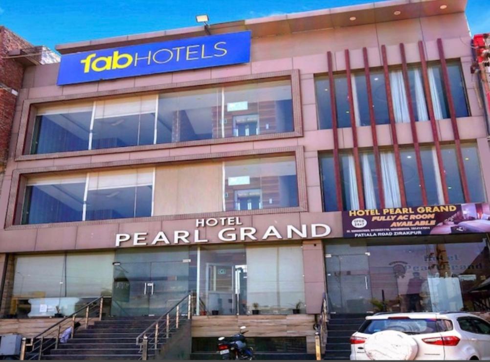 een gebouw met een hotel parel grand en een auto geparkeerd aan de voorkant bij The Peral Lodge - A beautiful lavish & luxuries Family Hotel in Zirakpur