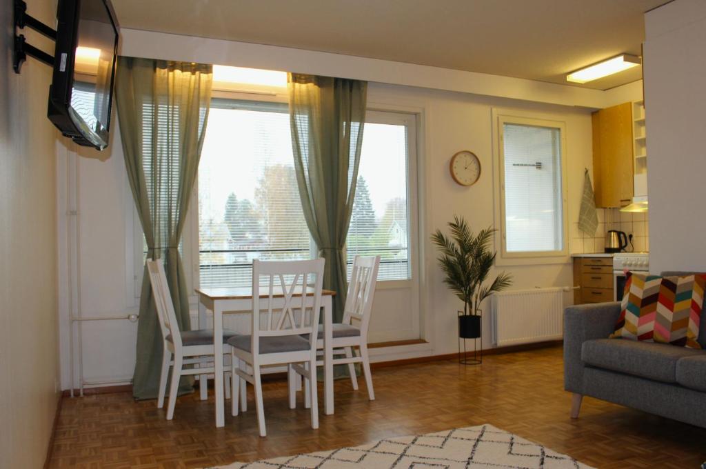 a kitchen and living room with a table and chairs at Kalustettu yksiö keskustassa in Raahe