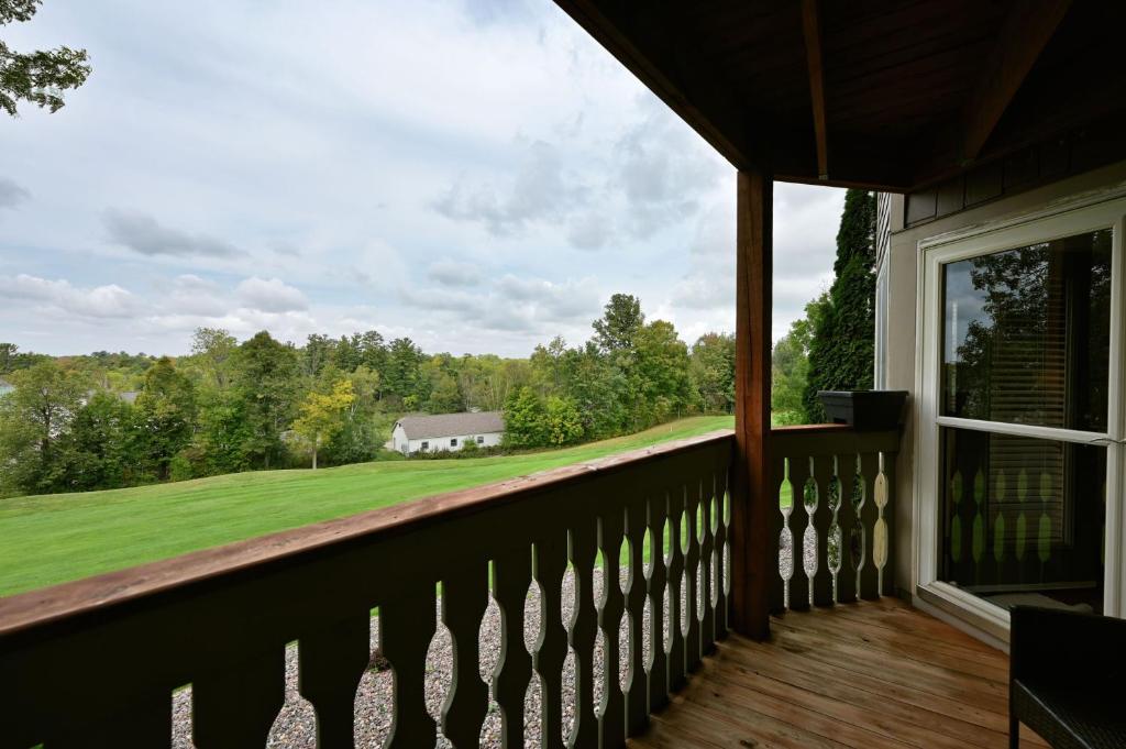 a balcony with a view of a farm with a house at Unit 109 2 BDRM 2 BA condo in Birchwood