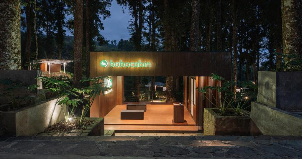 un edificio con una señal en medio de un bosque en Bobocabin Baturraden, Purwokerto, en Tenjo
