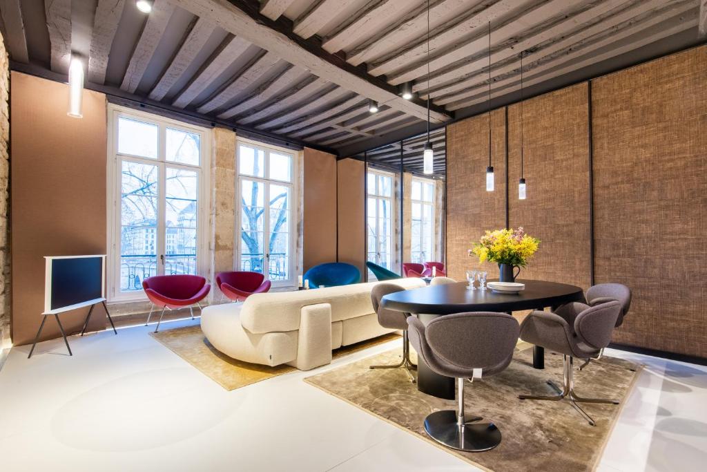 un salon avec un canapé, une table et des chaises dans l'établissement Sweett - Quai Bourbon, à Paris