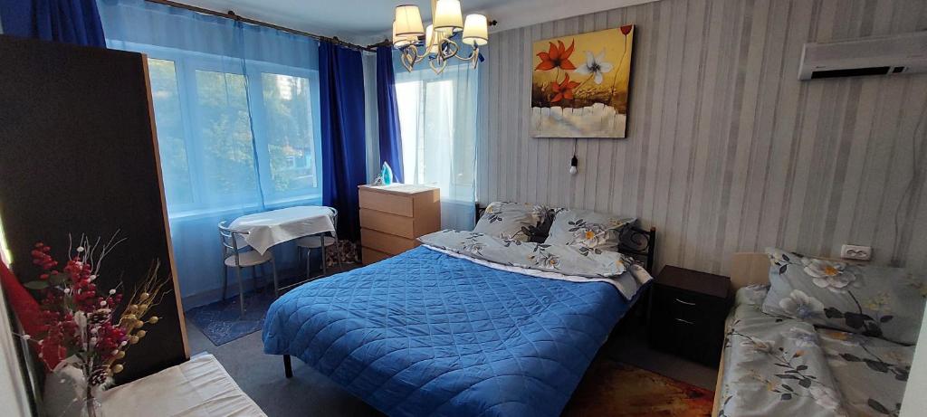 a bedroom with a blue bed and a window at 2 bedroom apartment metro Vasilkovskaya Institut Raka in Kyiv