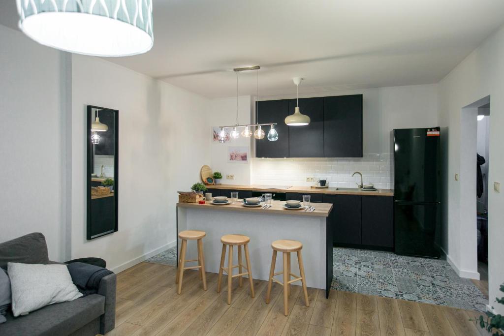 uma cozinha com um balcão e bancos num quarto em Apartament Szczerbowskiego A em Lublin