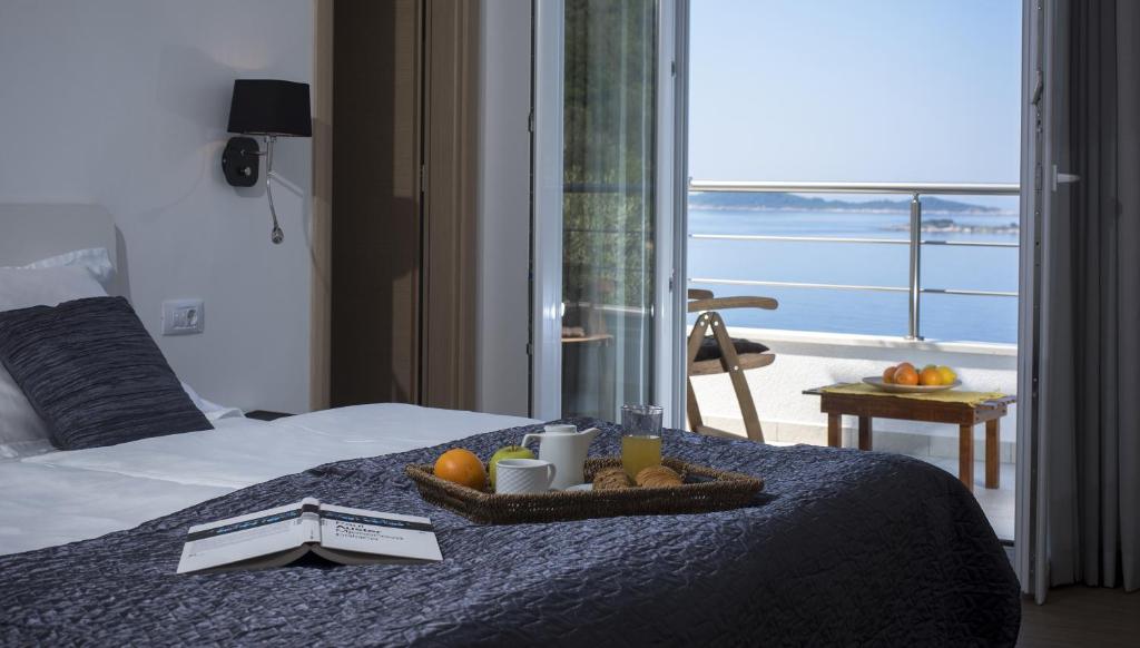una camera d'albergo con un letto e un vassoio di frutta di Comfort Zovko a Mlini