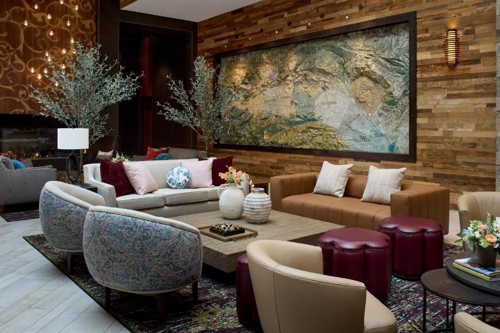 a living room with couches and a large painting on the wall at Archer Hotel Napa in Napa