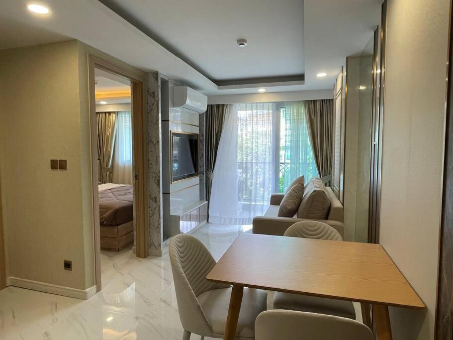 a living room with a table and a bedroom at Room at Pattaya, Jomtien Beach in Jomtien Beach