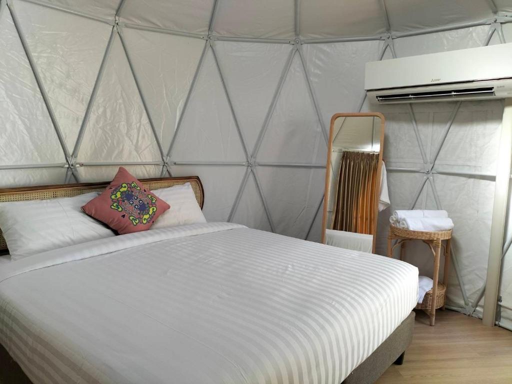 a bedroom with a white bed with a tent at ภูเพียงพอ ณ เชียงราย in Chiang Rai