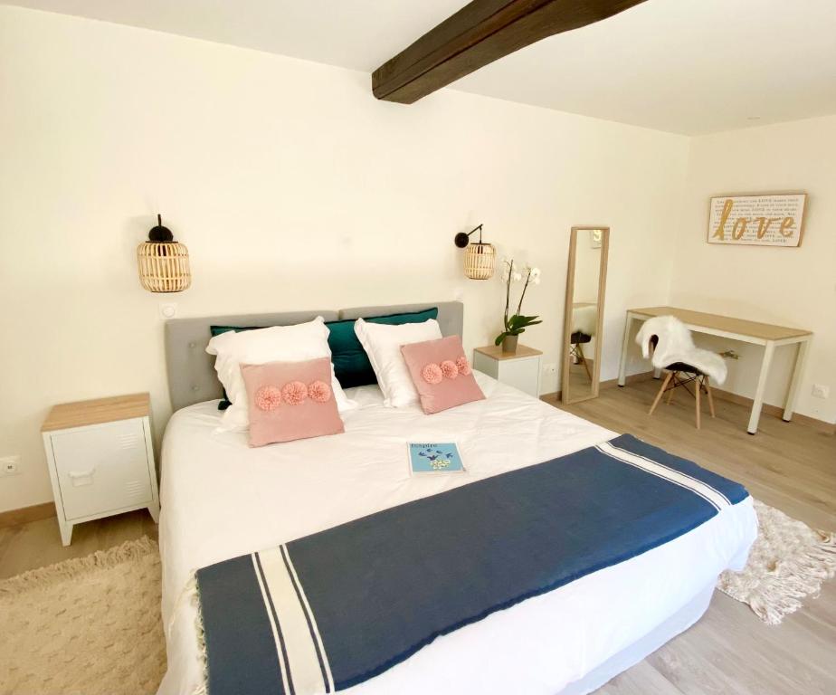 1 dormitorio con 1 cama grande con almohadas rosas en LES CHARMES en Jugy