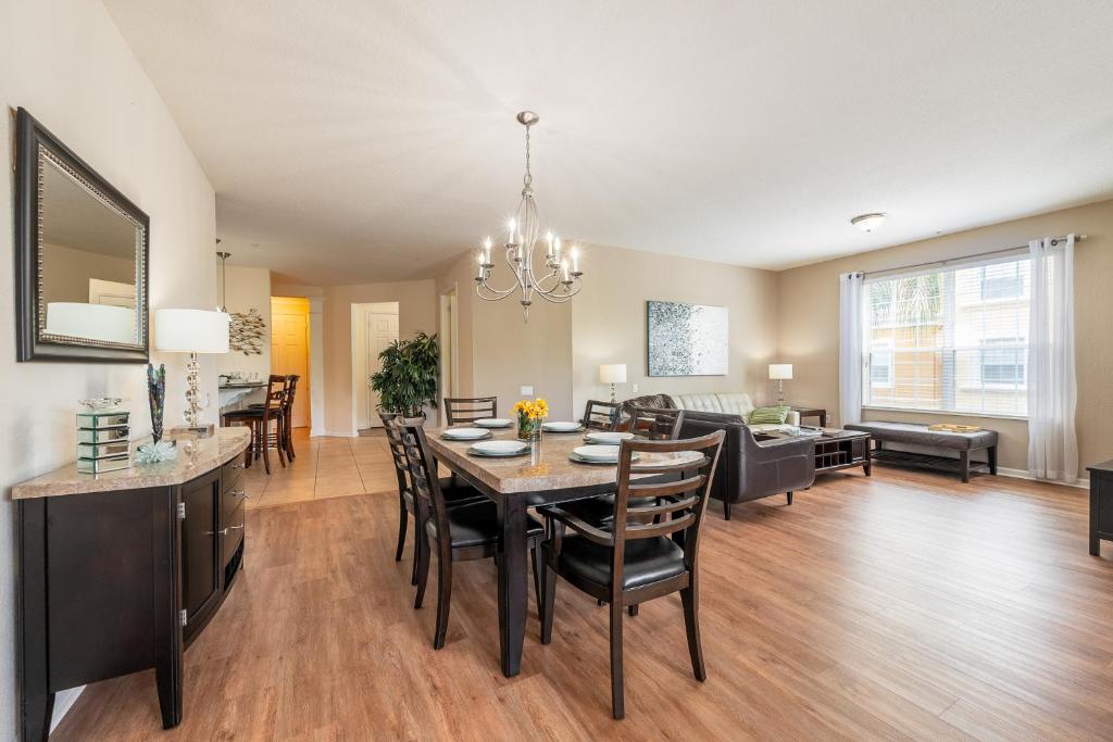 a dining room and living room with a table and chairs at Vista Cay Lakeview Island Breeze Near all theme Parks and Walk to Conventions in Orlando