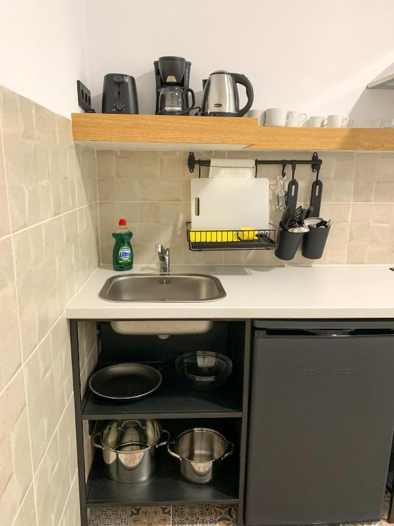 a kitchen counter with a sink and pots and pans at Apartamentos La Ruta in Calpe