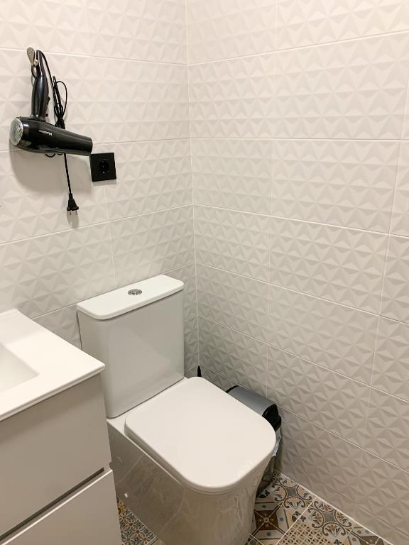 a bathroom with a white toilet and a sink at Apartamentos La Ruta in Calpe