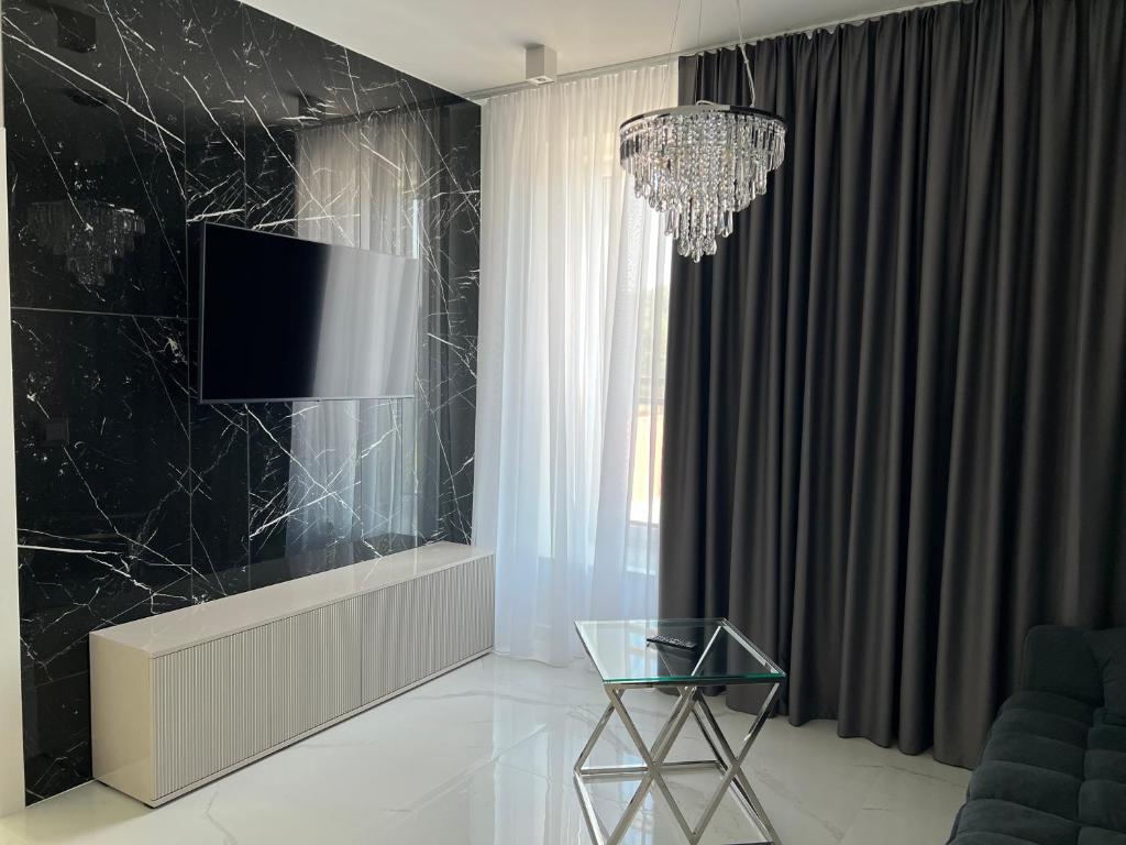 sala de estar con TV y mesa de cristal en Apartmány Ambiente en Kľušov