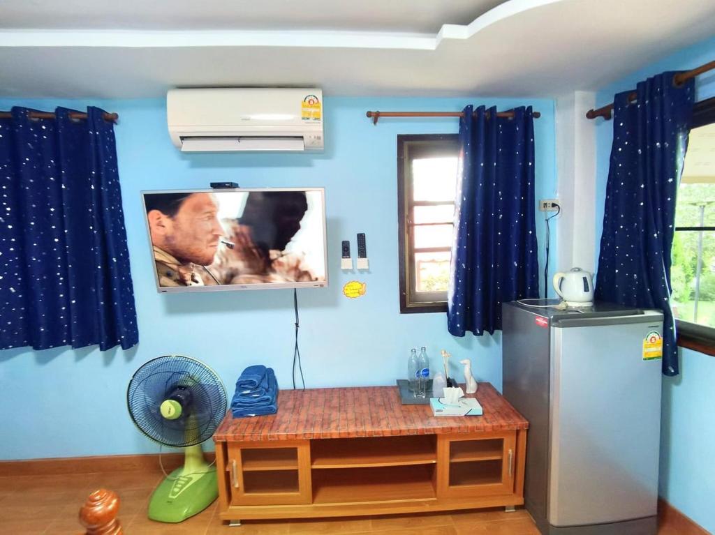 een kamer met een koelkast en een foto aan de muur bij Tonkaew Khaokao Resort in Campson