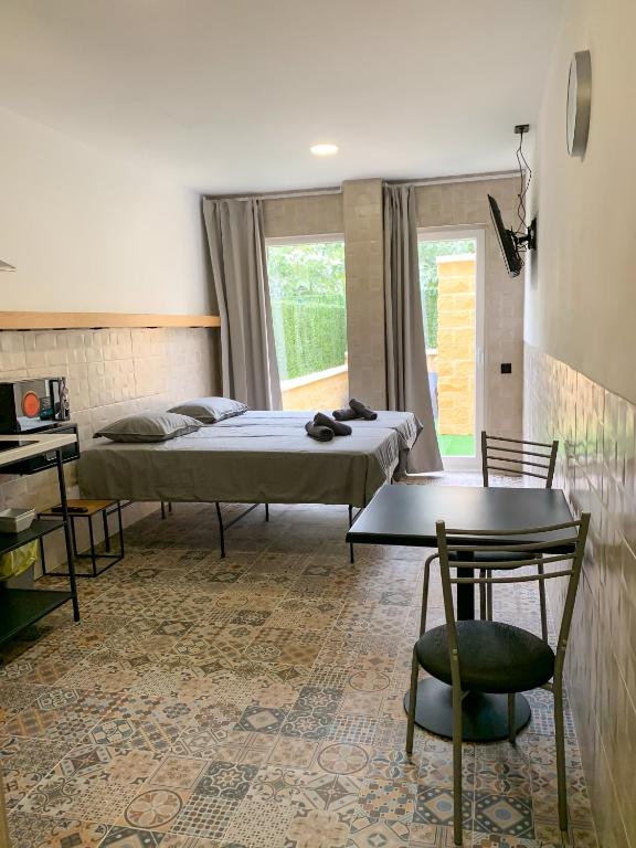 a bedroom with two beds and a table and a desk at Apartamentos La Ruta in Calpe