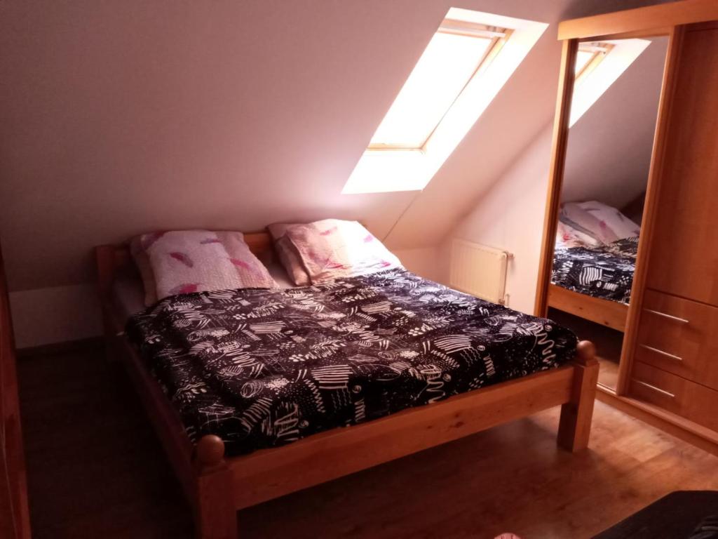 a small bedroom with a bed and a mirror at Apartament u Oli in Karpacz