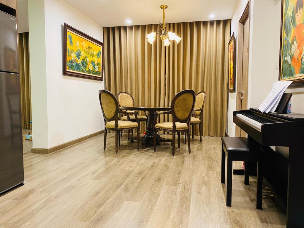a dining room with a table and a piano at BRAVO HOME Vinhomes Ocean Park in Hanoi